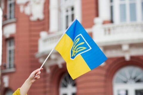Ukraińska flaga na tle budynku to symbol zaangażowania w projekt Odbudowa Ukrainy.